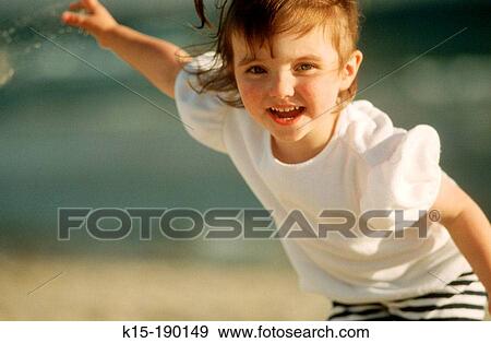 Young girl playing on beach View Large Photo Image Stock Photo - Young girl playing on beach. Fotosearch