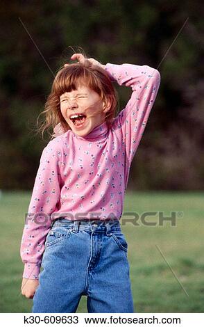 Stock Image - Young girl playing outdoors. Fotosearch