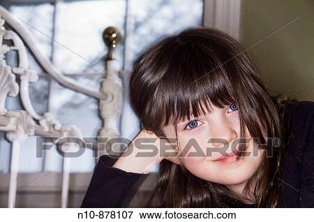 Stock Photo - Young girl posing in her bedroom.. Fotosearch