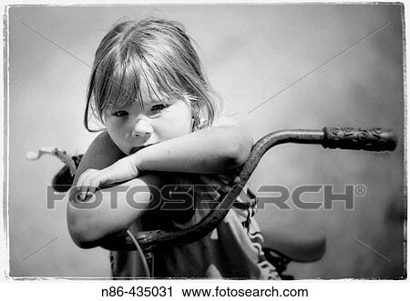 Young girl pouting while seated on a bike View Large Photo Image Stock Image - Young girl pouting while seated on a bike. Fotosearch