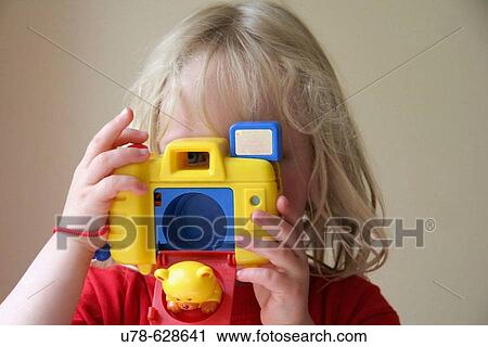 Young girl pretending to take photograph with toy camera View Large Photo Image Stock Image - Young girl pretending to take photograph with toy camera. Fotosearch