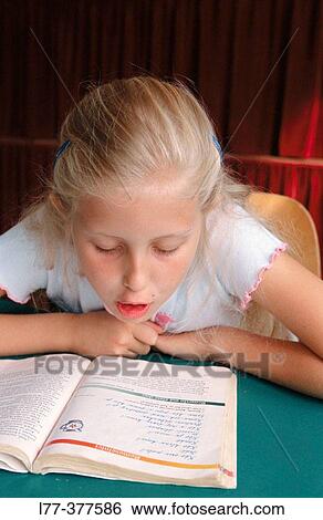 Young girl reading from text book at school View Large Photo Image Stock Photograph - Young girl reading from text book at school. Fotosearch
