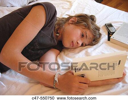 Stock Image - Young girl reading. Fotosearch