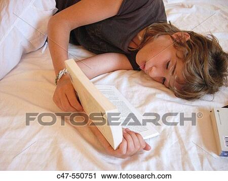Stock Image - Young girl reading. Fotosearch