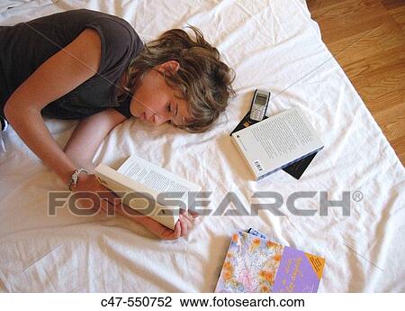 Stock Image - Young girl reading. Fotosearch