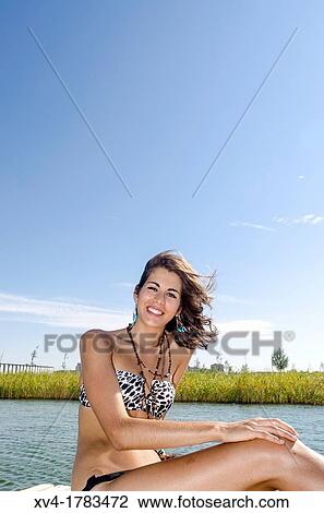 Stock Image - Young girl relaxed with bikini at lake in summertime. Fotosearch