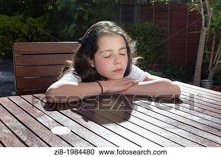 Stock Image - Young girl relaxes in the sun.. Fotosearch