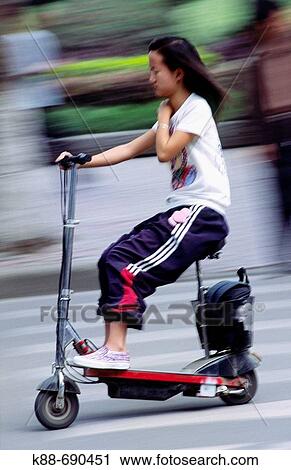 Young girl riding an electric scooter, Jinghong, Xishuangbanna, Yunnan, China View Large Photo Image Stock Image - Young girl riding an electric scooter, Jinghong, Xishuangbanna, Yunnan, China. Fotosearch