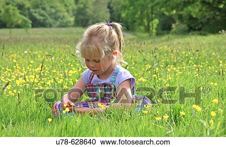 Young girl sat in buttercup meadow View Large Photo Image Stock Image - Young girl sat in buttercup meadow. Fotosearch