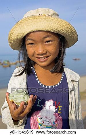 Stock Photo - Young girl selling sea shells at Lang Chai fishing village near Mui Ne Vietnam. Fotosearch