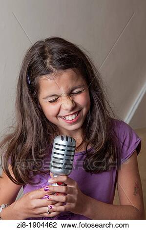 Young girl singing karaoke View Large Photo Image Stock Image - Young girl singing karaoke. Fotosearch
