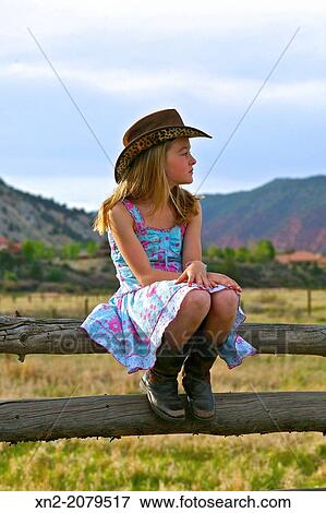 Young Girl Sitting on a Fence. View Large Photo Image Stock Photo - Young Girl Sitting on a Fence.. Fotosearch