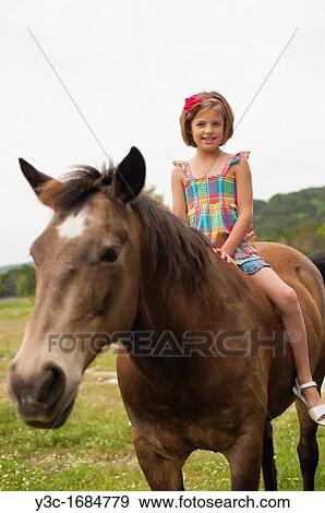 Young girl sitting on horseback attempting to ride a horse View Large Photo Image Stock Photo - Young girl sitting on horseback attempting to ride a horse. Fotosearch