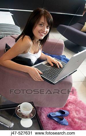 young girl sitting with a laptop smiing into camera View Large Photo Image Stock Image - young girl sitting with a laptop smiing into camera. Fotosearch