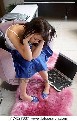 young girl sitting with a laptop looking depressed View Large Photo Image Stock Photo - young girl sitting with a laptop looking depressed. Fotosearch