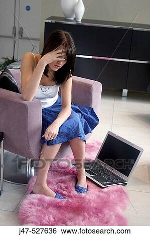 young girl sitting with a laptop looking really fedup View Large Photo Image Stock Photograph - young girl sitting with a laptop looking really fedup. Fotosearch
