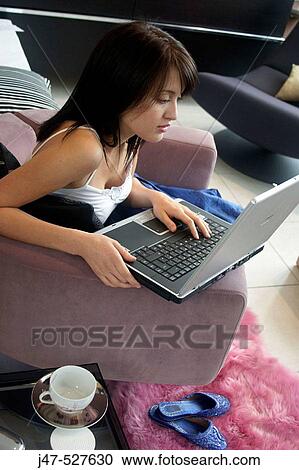 young girl sitting with looking at a laptop View Large Photo Image Stock Image - young girl sitting with looking at a laptop. Fotosearch