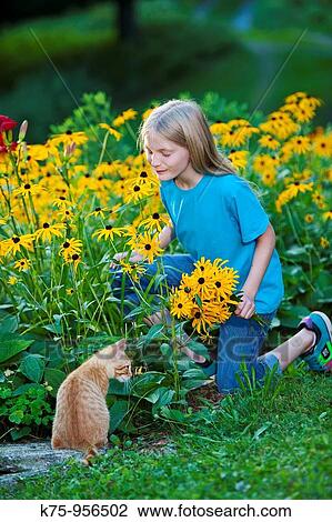 Stock Image - young girl smelling flowers. Fotosearch