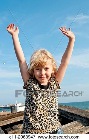 Stock Photo - young girl smiling and waving; Brighton, East sussex, England, Europe, UK.. Fotosearch