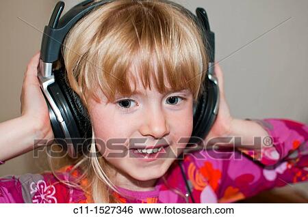 young girl smiling listening to music on headphones View Large Photo Image Stock Photograph - young girl smiling listening to music on headphones. Fotosearch