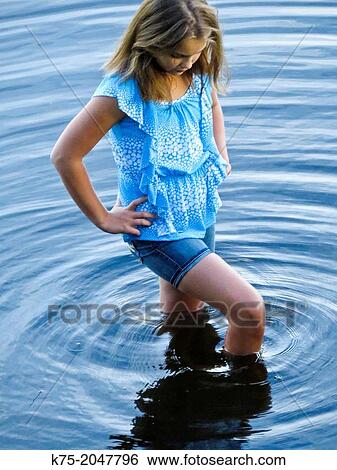 Young girl standing knee deep in water View Large Photo Image Stock Photograph - Young girl standing knee deep in water. Fotosearch