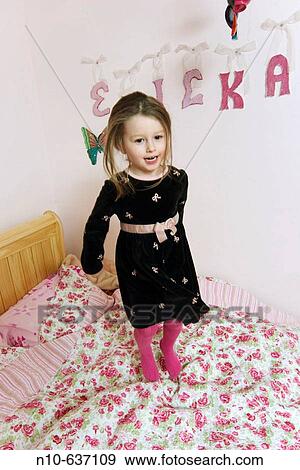 Young girl standing on her bed. View Large Photo Image Stock Photo - Young girl standing on her bed.. Fotosearch