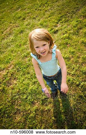 Young girl standing on the lawn, posing. View Large Photo Image Stock Photo - Young girl standing on the lawn, posing.. Fotosearch