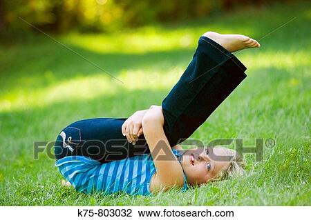 Young girl stretching on the lawn View Large Photo Image Stock Image - Young girl stretching on the lawn. Fotosearch