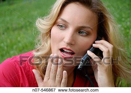 Young girl suprised having a phone call with a Cellular phone. View Large Photo Image Stock Photo - Young girl suprised having a phone call with a Cellular phone.. Fotosearch