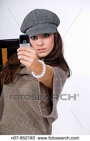 Stock Image - Young girl taking a picture of herself with her mobile phone. Fotosearch