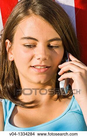 Young girl talking on her cell phone in a hammock, Germany, Europe View Large Photo Image Picture - Young girl talking on her cell phone in a hammock, Germany, Europe. Fotosearch