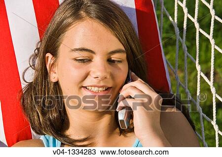 Young girl talking on her cell phone in a hammock, Germany, Europe View Large Photo Image Stock Image - Young girl talking on her cell phone in a hammock, Germany, Europe. Fotosearch
