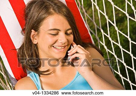 Young girl talking on her cell phone in a hammock, Germany, Europe View Large Photo Image Stock Photograph - Young girl talking on her cell phone in a hammock, Germany, Europe. Fotosearch
