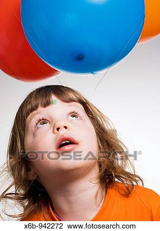 Young girl, three years old, looking up at balloons View Large Photo Image Stock Image - Young girl, three years old, looking up at balloons. Fotosearch