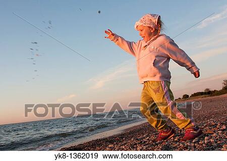 Stock Photo - Young Girl Throwing Stone into Water. Fotosearch