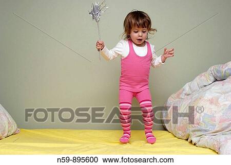 Young girl, two and half years old, bouncing on her bed with a fairy wand. View Large Photo Image Stock Image - Young girl, two and half years old, bouncing on her bed with a fairy wand.. Fotosearch
