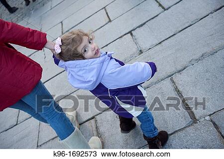 Stock Image - young girl walking with mom. Fotosearch