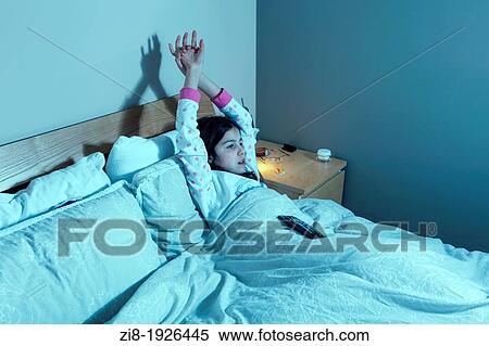 Young girl watches TV in parents bed View Large Photo Image Stock Photography - Young girl watches TV in parents bed. Fotosearch