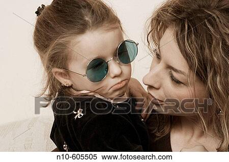 Young girl, wearing sunglasses, sitting with her mother. View Large Photo Image Stock Photography - Young girl, wearing sunglasses, sitting with her mother.. Fotosearch