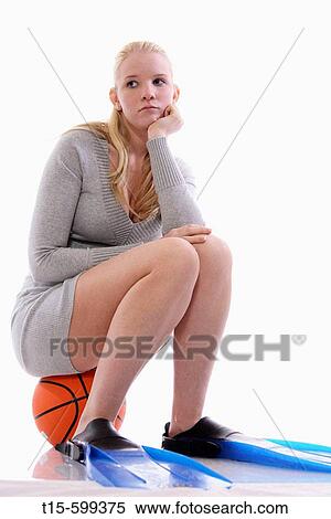 Young girl with acnes sitting on a basketball and wearing swimming flippers looking depressed View Large Photo Image Stock Photography - Young girl with acnes sitting on a basketball and wearing swimming flippers looking depressed. Fotosearch