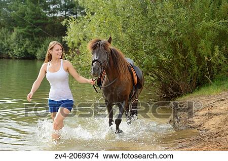 Picture - Young girl with an brown icelandic horse in summer, Bavaria, Germany.. Fotosearch