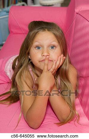 Young girl with big blue eyes stares into the camera with finger at lips. View Large Photo Image Stock Photography - Young girl with big blue eyes stares into the camera with finger at lips.. Fotosearch
