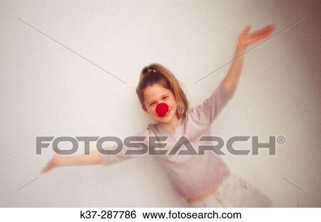 Stock Photograph - Young girl with clown nose portrait. Fotosearch