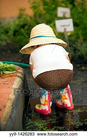 Stock Image - Young girl with hat and boots - Cabanas Del Lago - Lake San Pablo, near Otavalo, Ecuador. Fotosearch
