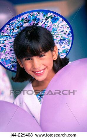Stock Photo - Young girl with hat and purple balloons. Fotosearch