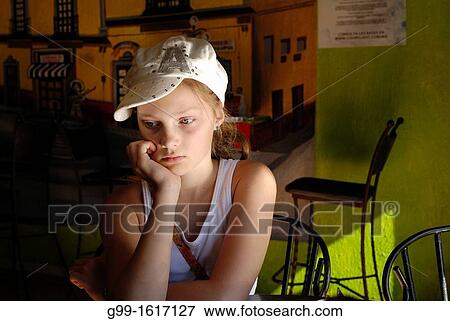 Stock Photo - Young girl with hat wating for fod at a restaurant, Nogales, Mexico. Fotosearch