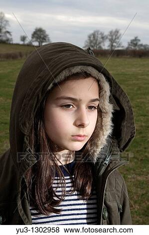 Young girl with hooded jacket standing in field View Large Photo Image Stock Photo - Young girl with hooded jacket standing in field. Fotosearch