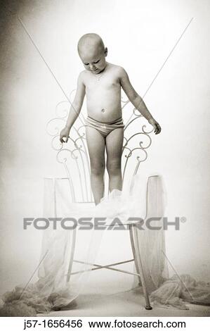 Stock Photograph - Young girl with pediatric cancer playing in studio with scarf. Fotosearch