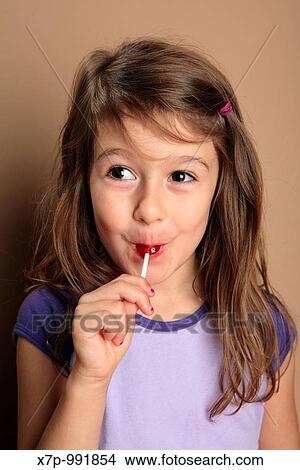 Picture - Young girl with red lollipop candy. Fotosearch