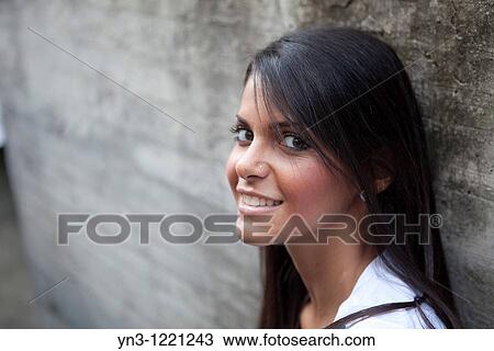 Young girl with straight long hair sitting against a concrete wall View Large Photo Image Stock Image - Young girl with straight long hair sitting against a concrete wall. Fotosearch